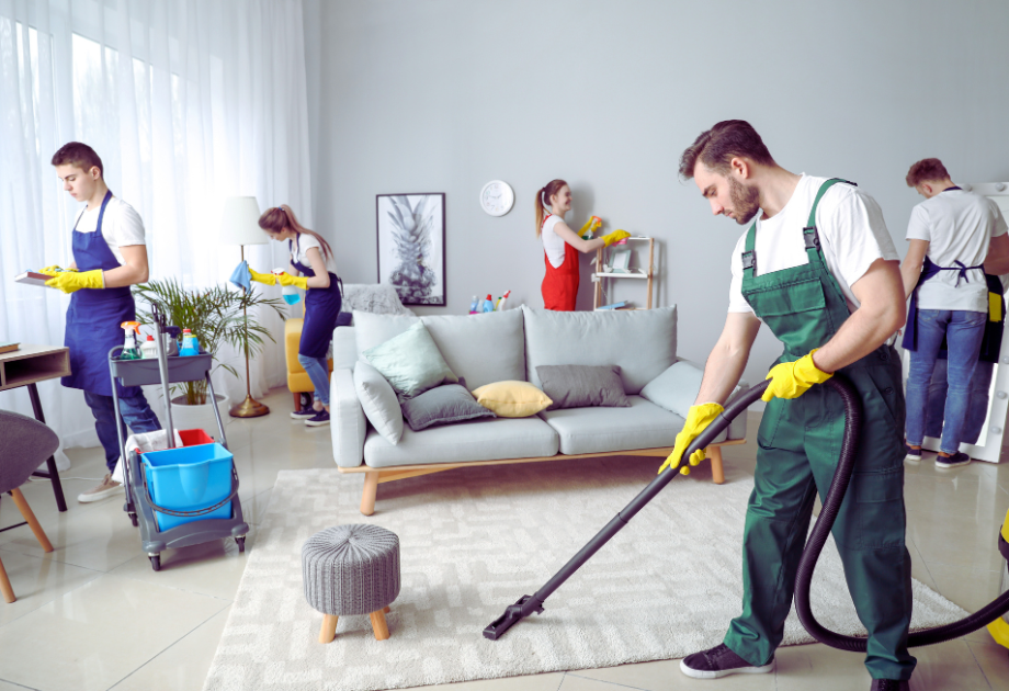 five people cleaning a living room